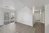 Bright and airy living space with modern wood flooring, large glass doors leading to a balcony, and a welcoming hallway.