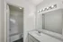 Bright, modern bathroom with sleek granite countertop, elegant lighting, and clean white fixtures.