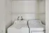 Modern apartment laundry area featuring a sleek washer and dryer set with an overhead storage shelf.