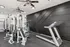 Modern fitness room with sleek black walls, high-end gym equipment, and a spacious layout for optimal workouts.