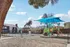 Bright and inviting apartment community playground with colorful equipment and a refreshing pool, perfect for family fun.
