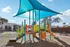 Vibrant playground area with colorful slides and climbing structures, shaded by a stylish canopy, offering a fun and inviting space for children.