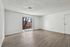 Bright and airy living space with elegant wooden floors and a charming view through glass doors leading to a balcony.