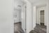 Bright hallway view showcasing elegant wood flooring, leading to a cozy bedroom and spacious closet.