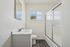 Bright and modern bathroom with elegant vanity, sleek shower, and natural light streaming through the window.