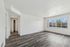Bright and spacious living area with elegant wood flooring, large window views, and a sleek modern design.