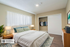 Bright and inviting bedroom with a plush bed, cozy lamps, and ample closet space, perfect for relaxation and comfort.