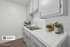 Sleek kitchen featuring modern white cabinetry, dual sink, and spacious countertop with fresh herb accents.