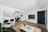 Chic and modern living space with stylish green velvet seating, sleek white cabinetry, and an inviting open-concept layout.