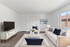 Chic and airy living room with modern furniture, plush white sofas, and elegant decor, showcasing a serene and inviting atmosphere.