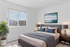 Bright and modern bedroom with large window views, elegant decor, and cozy bedding for a relaxing ambiance.