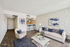 Modern living room with stylish decor, featuring a white sofa, elegant armchair, and a cozy open-concept design.