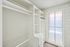 Bright walk-in closet with ample shelving and natural light, perfect for organized living.