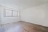 Bright, inviting room with elegant wood floors and large window blinds, perfect for customization.