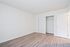 Bright, spacious room with elegant wood flooring and a sleek sliding closet, perfect for modern living.