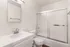 Modern bathroom featuring sleek fixtures, a pristine countertop, and a glass-enclosed shower for a luxurious feel.