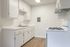 Bright and inviting kitchen with modern white cabinetry, sleek countertops, and a gas stove, offering a perfect space for culinary creativity.