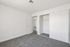 Bright and airy bedroom with plush carpeting, featuring a spacious closet and modern white walls.