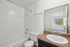 Bright and inviting bathroom with elegant fixtures, sleek vanity, and a window view adding natural light.