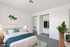 Bright, virtually staged bedroom featuring modern decor, a cozy bed with blue accents, and an inviting walk-in closet.