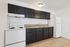 Modern kitchen with sleek dark cabinetry, spacious countertops, and a convenient white appliance set pairing perfectly with tile flooring.