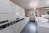 Bright and clean communal laundry room with modern washing and drying machines, featuring a large window for natural light.