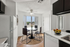 Bright and modern kitchen with a cozy dining area, featuring a round table with four sleek chairs, large windows enhancing light, and elegant floral d&eacute;cor.