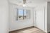Bright room with a sleek ceiling fan, large window offering a scenic view, and chic wood flooring.