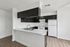 Modern kitchen with sleek dark cabinetry, white countertops, and stainless steel sink, offering a stylish and functional space for culinary creativity.