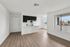 Bright, open-plan living space with sleek kitchen, modern flooring, and large windows offering ample natural light.