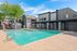 Inviting apartment complex with a sparkling outdoor pool surrounded by vibrant landscaping and modern architecture.
