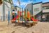 Vibrant playground with colorful slides and climbing structures, nestled in a charming apartment community.