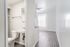 Modern apartment interior with a sleek bathroom and sunlit room featuring elegant vinyl plank flooring and contemporary design.