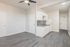 Modern apartment interior featuring sleek grey flooring, elegant white cabinetry, and a stylish kitchen with mosaic backsplash for an inviting atmosphere.