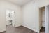 Bright and inviting bedroom with sleek hardwood flooring, featuring a compact, stylish bathroom and a spacious closet.