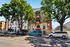 Charming urban apartment building with classic brick facade, surrounded by lush trees and conveniently located on a bustling street.