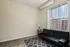 Cozy living space with plush black sofa, elegant floral decor, and large window offering ample natural light.