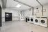 Modern and spacious laundry room equipped with multiple washers and dryers, perfect for convenient and efficient laundry days.