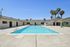 Inviting apartment complex with a sparkling outdoor pool, surrounded by palm trees and modern amenities, offering a perfect Californian lifestyle.