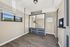 Bright room with ample storage, featuring a large mirrored wardrobe and natural light from wide windows, enhancing the elegant wood flooring.