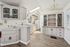 Charming kitchen with elegant cabinetry, ample counter space, and modern appliances, featuring a vintage-style chandelier and natural light.