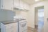 Bright kitchen with modern cabinetry and a gas stove, leading into an inviting room with natural light.