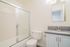 Modern bathroom featuring sleek vanity with stylish fixtures, elegant bathtub with glass doors, and bright, inviting atmosphere.