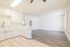 Bright and modern open-concept kitchen and living area with sleek white cabinetry and elegant wooden flooring.