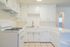 Bright and inviting kitchen with sleek white cabinetry, modern gas stove, and spacious countertops perfect for culinary adventures.