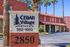 Charming Cedar Village Apartments with desert-inspired architecture, surrounded by palm trees and offering inviting communal spaces.