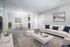 Chic and modern living room with plush white sofa, blue accent pillows, and elegant glass dining set in open-concept layout.