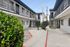 Charming apartment complex courtyard featuring modern architecture, lush greenery, and convenient mailboxes.