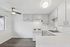 Bright and airy kitchen featuring modern white cabinetry, sleek countertops, and stainless steel fixtures, perfect for culinary creativity.