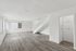 Sleek and modern open living space with elegant staircase, large windows, and stylish wood flooring, perfect for a bright and airy atmosphere.